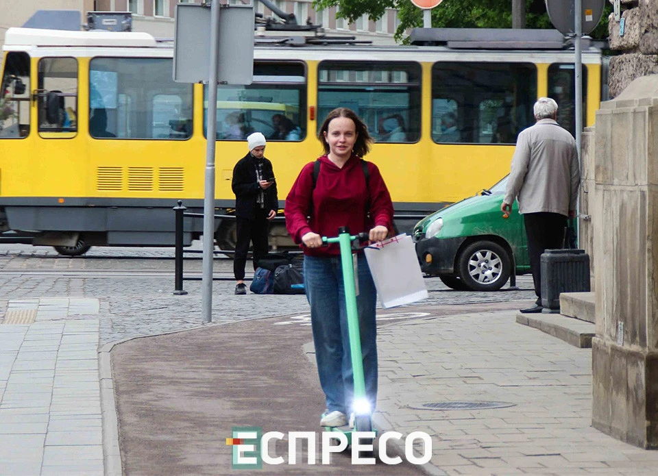 львів'янка Зоряна їде по велодоріжці біля Оперного театру.